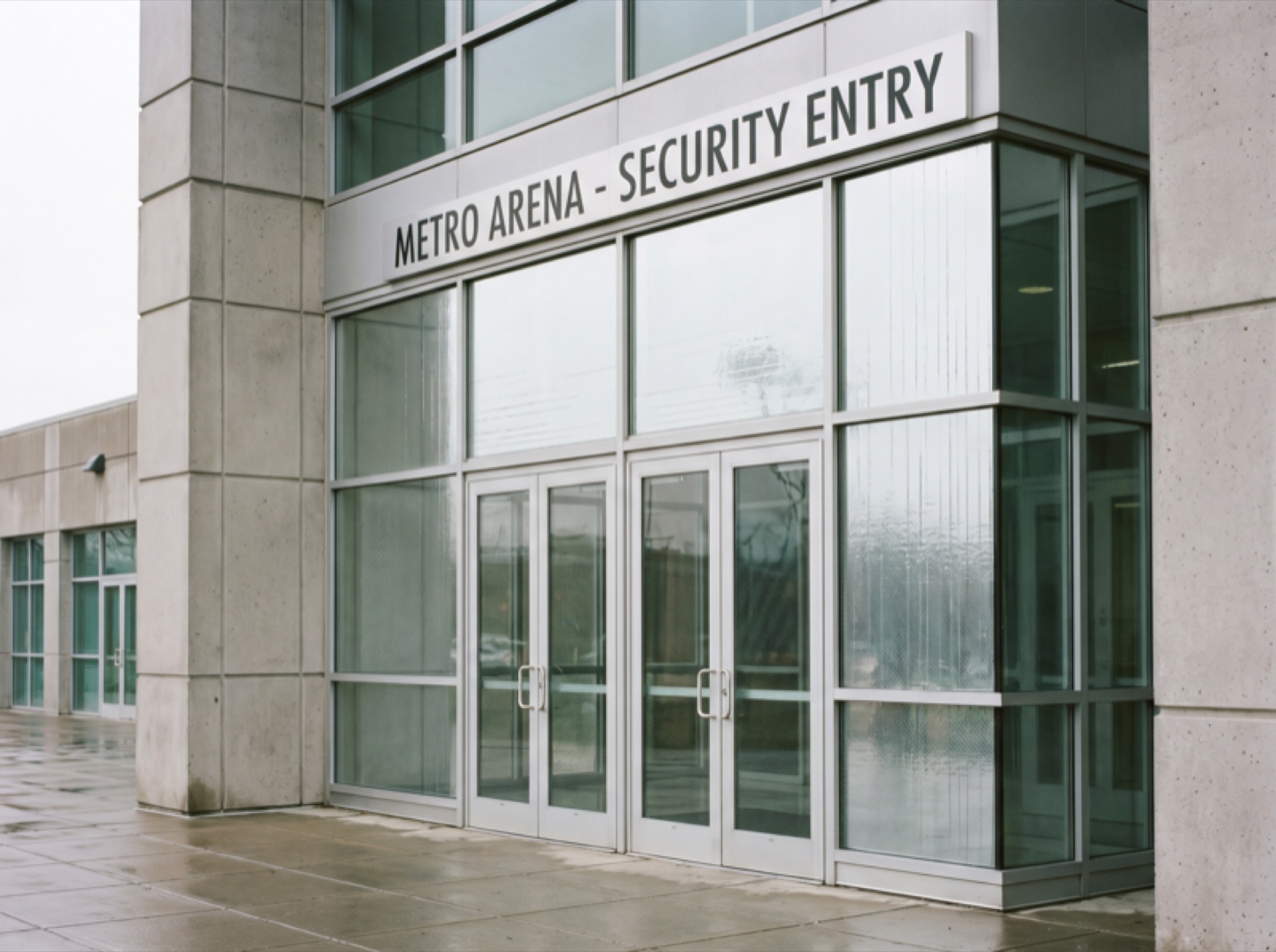 Arena entrance with security window film on glass doors — modern institutional architecture