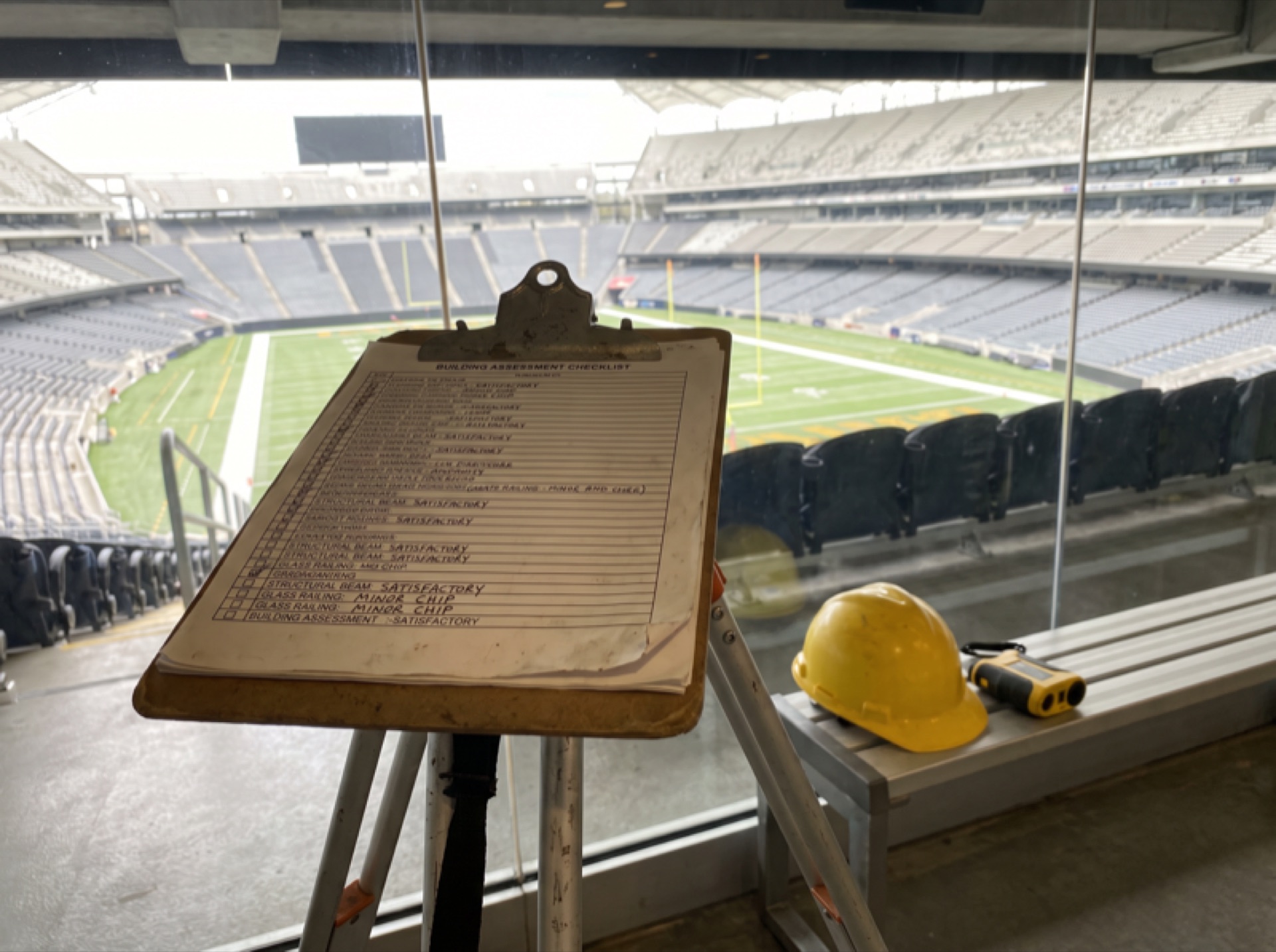 Building assessment checklist on a clipboard in an arena glass concourse
