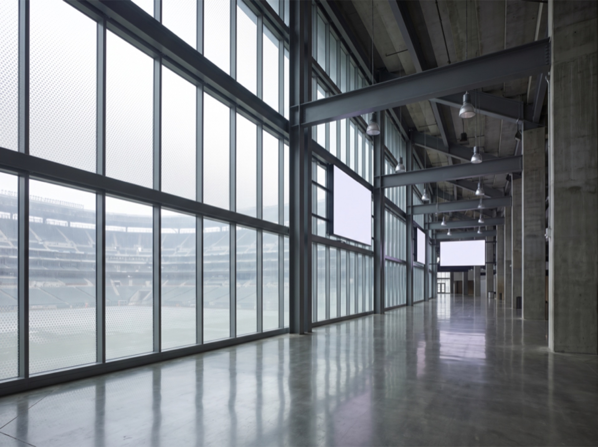 Sports arena interior concourse with glass curtain wall and solar control window film