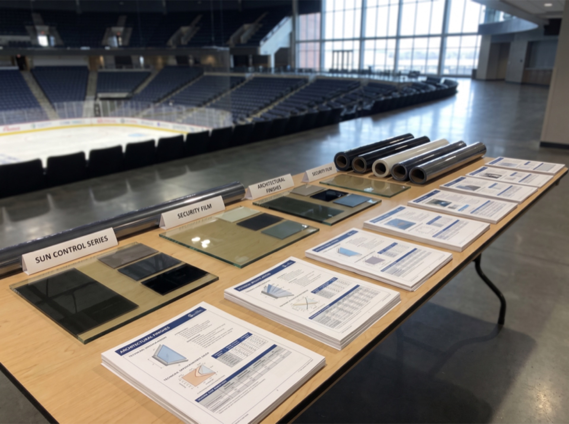 Window film specification sheets and product samples laid out for arena installation planning